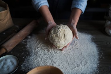 Eller pizza yapımı için hamur yoğurun. Ahşap tahtada pizza veya ekmek pişirme için taze çiğ hamur.