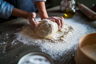 Eller pizza yapımı için hamur yoğurun. Ahşap tahtada pizza veya ekmek pişirme için taze çiğ hamur.