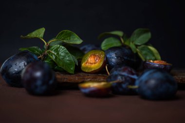 Koyu ahşap bir arka plan üzerinde damla erik. Tonlama. Seçici odaklama.