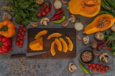 Rustik kesme tahtası üzerinde sebze malzemelerle dilimlenmiş kabak. Lezzetli vejetaryen yemek. Bio sağlıklı gıda, otlar ve baharatlar. Organik sebzeler. Rustik tarz. Üst te. Tonlu görüntü.