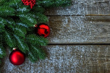 Noel ağacı dalları, dekorasyon ve kırmızı topları ile tebrik kartı için Noel arka plan, koyu ahşap tahta üzerinde. Metin için kopyalama alanı ile üst görünüm.