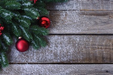 Noel ağacı dalları, dekorasyon ve kırmızı topları ile tebrik kartı için Noel arka plan, koyu ahşap tahta üzerinde. Metin için kopyalama alanı ile üst görünüm.