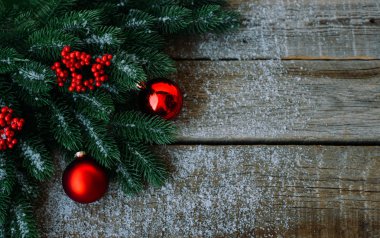 Noel ağacı dalları, dekorasyon ve kırmızı topları ile tebrik kartı için Noel arka plan, koyu ahşap tahta üzerinde. Metin için kopyalama alanı ile üst görünüm.