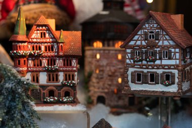 Almanya'da Noel pazarı. Gingerbread evler bir gösteri penceresinde görüntülenir. Arka planda Noel ışıkları var. Münih, Almanya'daki Noel Pazarı'nda stand.