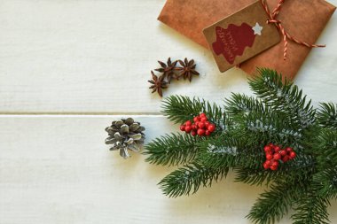 Noel hediyeleri, çam dalları, beyaz arka plan üzerinde kırmızı meyveler. Düz yatıyordu, üstten bak. Kopyalama alanı.