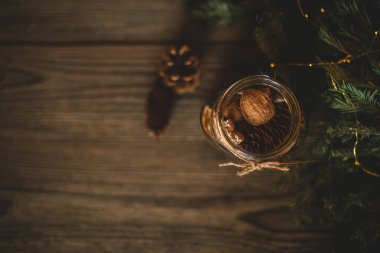 Ev yapımı zencefilli kurabiye, fındık ve çikolata ile Noel hediyesi. Cam kavanoz, köknar dalları, Noel baharat ve dekor. Kış tatilleri, Yeni Yıl veya Noel konsepti. Kopyalama alanı ile üstte görünüm.