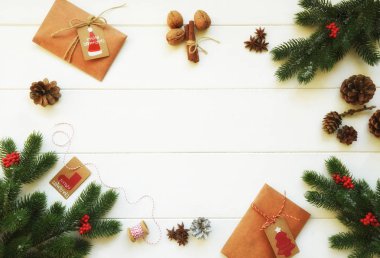 Noel çerçeve köknar dalları, kırmızı çilek, spises ve hediyeler beyaz ahşap backgraund üzerinde yapılmış. Noel duvar kağıdı. Düz döşeme, üst görünüm, kopyalama alanı.