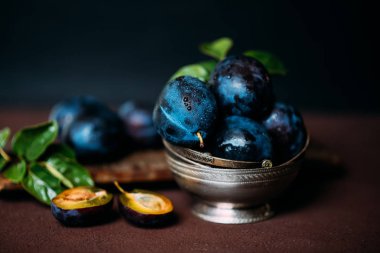 Masada olgun sulu erik ile Bowl. Taze organik erik. Yaz hasadı. Sonbahar hasadı. Güzel natürmort. Tonlu görüntü. Seçici odaklama.