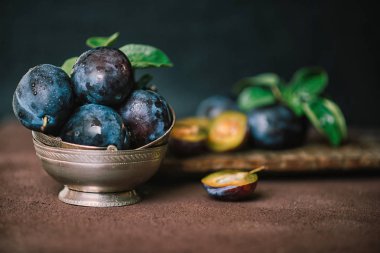 Kahverengi yüzey arka plan üzerinde gümüş vintage kase Organik taze erik. Sağlıklı yaşam tarzı yaz vejetaryen gıda. Kır bahçe meyve konsepti. Güzel natürmort. Kopyalama alanı ile tonlu görüntü.