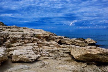 Bir koy ve kaya ile Kayalık kıyı şeridi, su yüzeyi üzerinde bölünmüş görünümü, Akdeniz, İspanya. Masmavi deniz, dalga ve mavi gökyüzü. Deniz manzarası ve bulutlu derin mavi gökyüzü ile Seascape. Ekolojik turizm