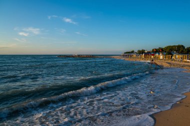 Sonsuz ufuk ve uzakta rakamlar ve inanılmaz köpüklü dalgalar ile Amazing plaj.