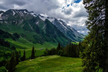 Güzel dağlar manzarası. Tyrol, İtalya'da vadide küçük bir köy ile yaz aylarında Dolomites Dağı kaplı kar görünümü.