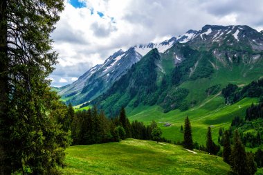 Güzel dağlar manzarası. Tyrol, İtalya'da vadide küçük bir köy ile yaz aylarında Dolomites Dağı kaplı kar görünümü.