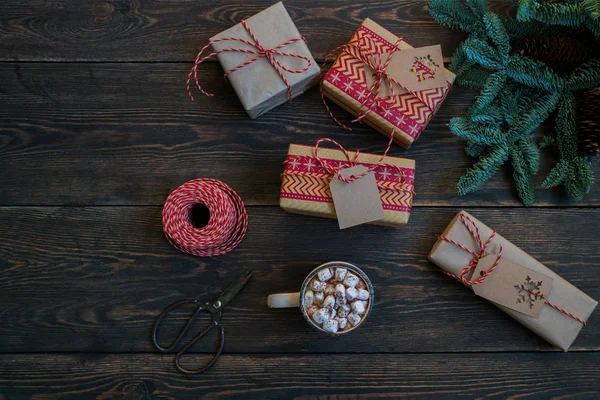 素朴な木製のボード上の装飾やギフトボックスとクリスマスの背景 プレゼント 松ぼっくり モミの枝 星とひもリボン 休日の準備 トーン画像 — ストック写真