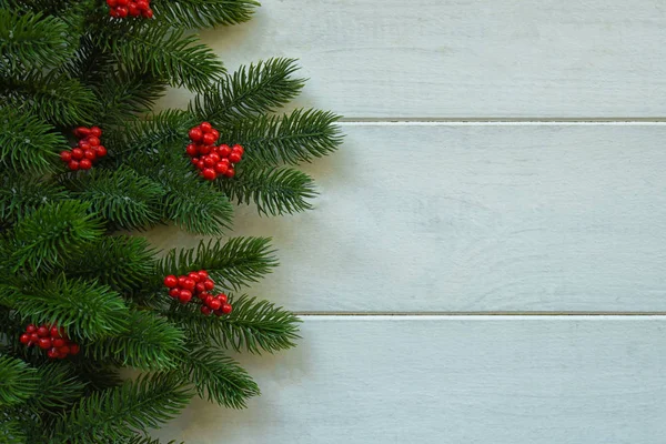 モミの枝と赤いベリーとクリスマス木製の背景 コピースペースを使用した表示 — ストック写真