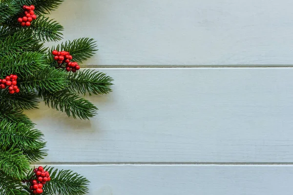 モミの枝と赤いベリーとクリスマス木製の背景 コピースペースを使用した表示 — ストック写真