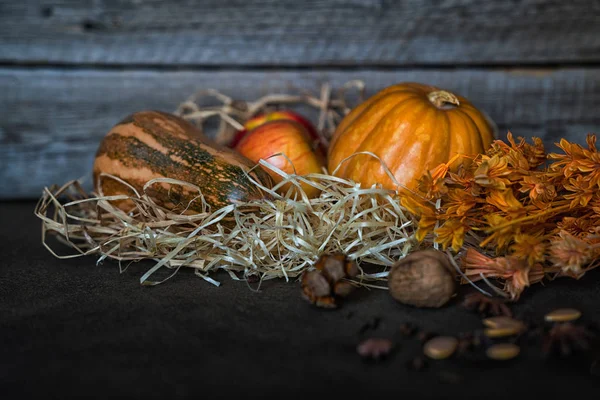 感恩节南瓜和落叶在简陋的木板在谷仓 一个乡村的秋天静物与暗木背景 老风化木板前稻草上的蔬菜和水果 — 图库照片