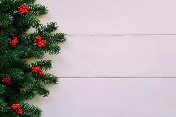 モミの枝と赤いベリーとクリスマス木製の背景 コピースペースを使用した表示 — ストック写真