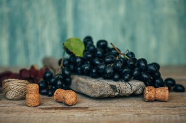 Eski gri ahşap yüzeyinde olgun mavi üzüm. Tonlu görüntü.