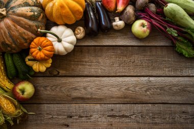 Sağlıklı organik sebze çerçeve. Çiftlik taze sebze ve meyve üst görünümü. Ahşap yüzey üst görünümünde ot mutfak bahçesi ile Hasat sebze. Vegan gıda natürmort.