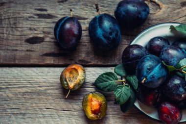 Rustik mutfak masasında olgun sulu erik ile Colander. Sağlıklı vejetaryen yemekleri. Biyo, organik yemek. Üst te. Kopyalama alanı.