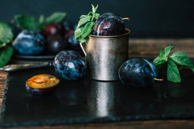 Yaprak ve su damlaları ile Erik. Sonbahar hasadı. Biyo, organik gıda. Sağlıklı vejetaryen yemekleri. Taze organik meyveler. Yemek geçmişi. Tonlu görüntü.