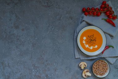 Sonbahar sebze ve kabak çekirdeği ile bir kapta kabak çorbası. Vegan çorbası. Sebze krema çorbası ve malzemeler. Üst te. Sağlıklı beslenme veya vejetaryen gıda kavramı. Kopyalama alanı ile üstte görünüm.