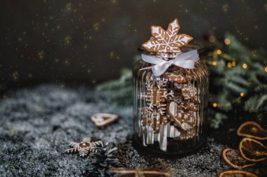 Arka planda köknar dalları ile cam kavanozda ev yapımı zencefilli, baharat ve dekor. Tatiller, kış, Noel konsepti sunar. Mutlu Noeller ve Mutlu Tatiller. Tonlu görüntü. Yumuşak odaklama.