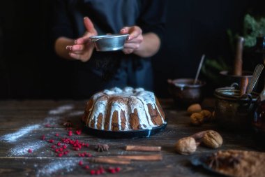 Ev rustik mutfakta ev yapımı kek Noel arifesi pişirme. Kadının elleri puding yapar. Koyu ahşap masada noel pişirme için malzemeler. Mutlu Noeller ve Mutlu Tatiller! Tonlu görüntü.