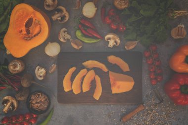 Rustik kesme tahtası üzerinde sebze malzemelerle dilimlenmiş kabak. Lezzetli vejetaryen yemek. Bio sağlıklı gıda, otlar ve baharatlar. Organik sebzeler. Rustik tarz. Üst te. Tonlu görüntü.