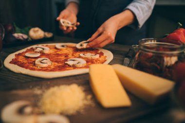Pizza sanatı. Pizza yapma süreci. Masada malzemeler ve baharatlar ile pizza için çiğ hamur. Koyu ahşap arka planda geleneksel İtalyan pizza ve sebzeleri. Pizza menüsü. Yumuşak odaklama.