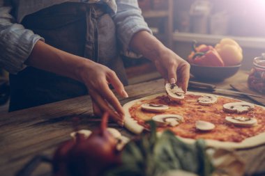 Yemek pişirmek için gıda malzemeleri ve baharatlar. Mantar, domates, peynir, soğan, yağ, biber, tuz, fesleğen, zeytin ve koyu ahşap arka plan üzerinde lezzetli İtalyan pizza. Pizza menüsü. Ev yapımı yemek.
