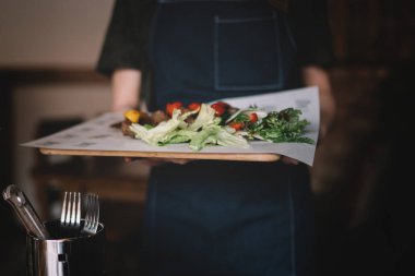 Garson restoranda salata ve ızgara et servis, yakın görüş. Yeme ve eğlence konsepti. Tonlu görüntü. Seçici odaklama.