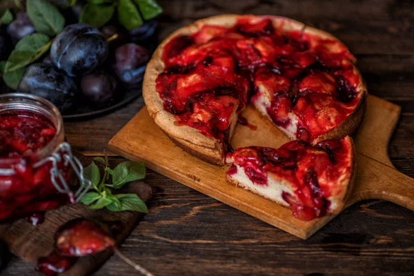 Fruit pie. Sweet pie, tart with fresh plums. Delicious cake with plums. Fall harvest concept. Fresh plums with leaves. Healthy, organic food. Toned image.