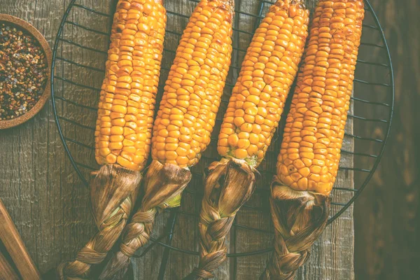 Summer or autumn food background. Ideas for barbecue and grill parties. Grilled corn, cheese on a dark wooden table. Healthy food, organic, bio, homemade food. Top view.