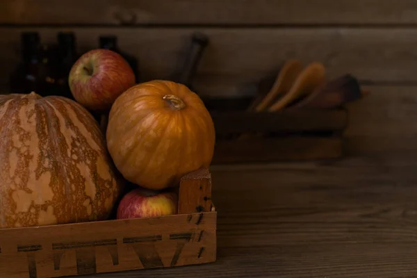 Autumn concept with seasonal vegetables for Thanksgiving Day. Fresh vegetables on dark table. Healthy eating. Squash, pumpkins and apples. Recipes or menu card. Flat lay, copy space. Toned image.