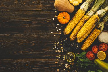 Ahşap vintage masada tereyağı ve sebze eritme ile ızgara tatlı mısır koçan ile rustik mutfak masasının üst görünümü. Organik sarı mısır yemeye hazır.