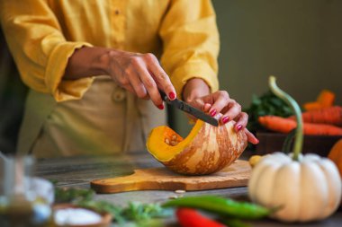 Mutfak bıçağı ve lezzetli vejetaryen yemek için mantar ve sebze malzemelerle rustik kesme tahtası üzerinde doğranmış kabak, koyu tarz.