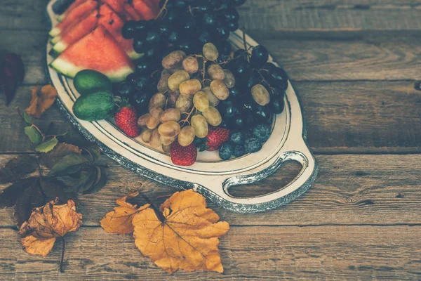 Vintage tray with autumn fruits on rustic vintage table top view. Fresh organic fruits. Food background. Healthy food. Top view. Toned image.
