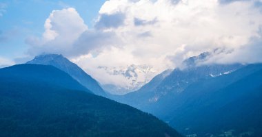 Güzel bir doğa geçmişi var. Dağlardaki harika bahar manzarası. Ormanlı dağ yamaçları alçak bulutlar içinde ebedi yeşil kozalaklı manzaralı..