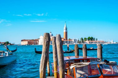 Venedik, İtalya 'da San Giorgio di Maggiore kilisesi ile birlikte Saint Mark meydanına demirlemiş Gondolas ve motorlu tekneler. Venedik 'in mimarisi ve simgeleri.