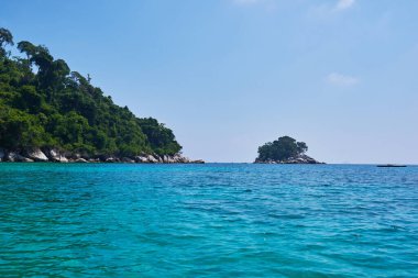 Turkuaz deniz, yağmur ormanı, kayalar, okyanus. Tropik cennet adasını keşfediyorum. Mükemmel bir kaçış. Rahatlatıcı. Seyahat konsepti ve fikri. Güzel gök mavisi okyanus.