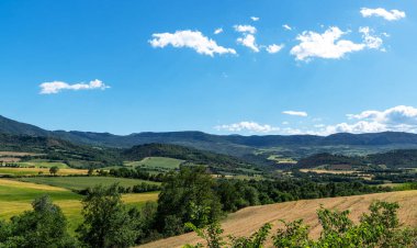 Katalonya, İspanya 'daki Montsec dağlarının engebeli güzelliği. Sahne yuvarlanan tepeler ve berrak mavi bir gökyüzü içeriyor, bölgenin tipik bir manzarası olan pitoresk ve sakin bir manzara oluşturuyor.