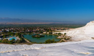 Pamukkale 'nin çarpıcı manzarasında turkuaz termal sularla dolu beyaz travertin havuzlar gerçeküstü bir manzara yaratıyor..