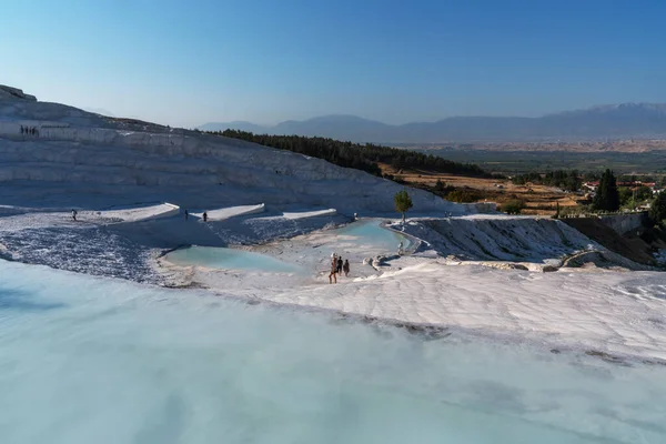 Pamukkale 'nin çarpıcı manzarasında turkuaz termal sularla dolu beyaz travertin havuzlar gerçeküstü bir manzara yaratıyor..