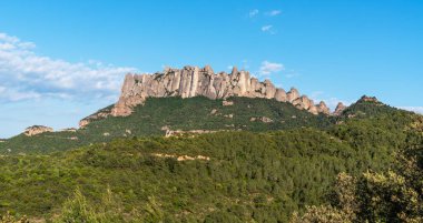 Ayırt edici kaya oluşumları, yemyeşil ormanlar ve açık mavi gökyüzü ile engebeli Montserrat sıradağlarının nefes kesici manzarası Katalonya manzarasının doğal güzelliğini gözler önüne seriyor..