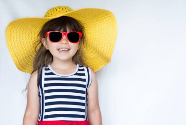 Hasır şapka, sevimli küçük kız ve Studio beyaz arka plan üzerinde renkli elbise portresi. Metin için yer kopyalayın