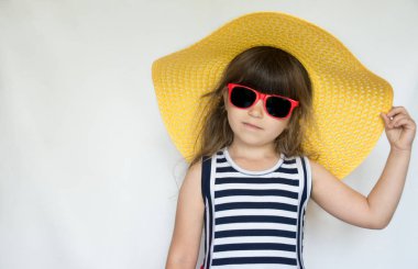 Yaz elbise şapka ve beyaz arka plan üzerinde duran güneş gözlüğü ile çok güzel moda küçük modeli. Yaz tatil mutlu bir çocuk. Seyahat ve macera kavramı
