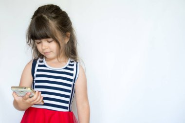 Smartphone kullanarak ve gülüyor sevimli küçük kız. Cep telefonu, beyaz arka plan, metin için boş alan ile mutlu çocuk.