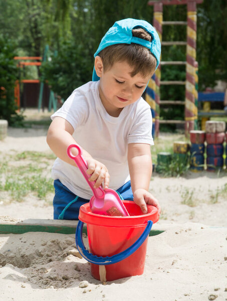 Little boy on playground in summer park. Toddler playing outdoor.